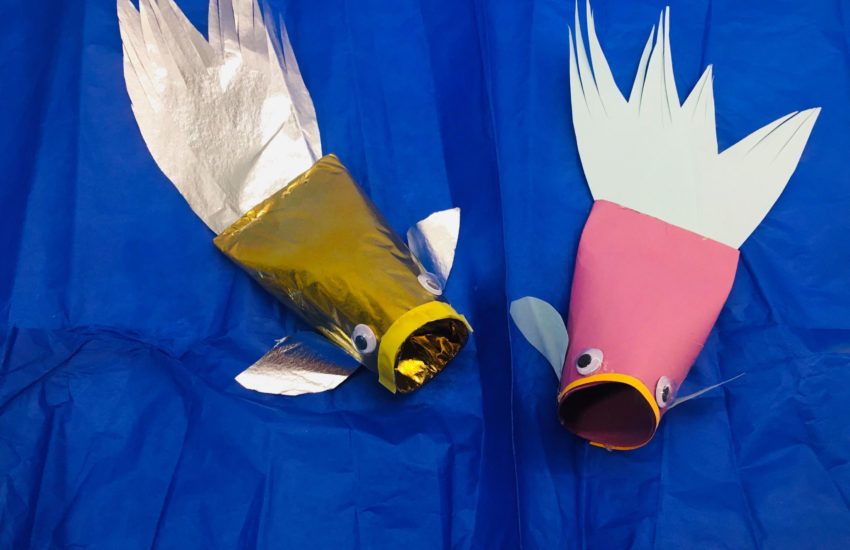 Pyssel - en guld och en rosa silverfisk på blått papper